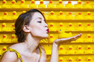 Femme qui fait un bisou vers un canard en plastique