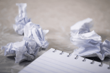 Carnet entouré de feuilles de papier mises en boule